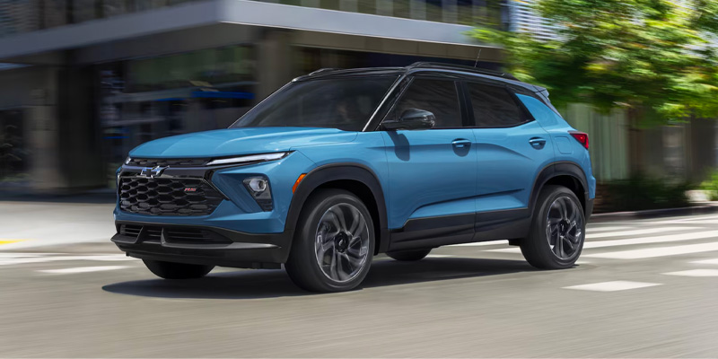 Blue Chevrolet Trailblazer driving on a city street.